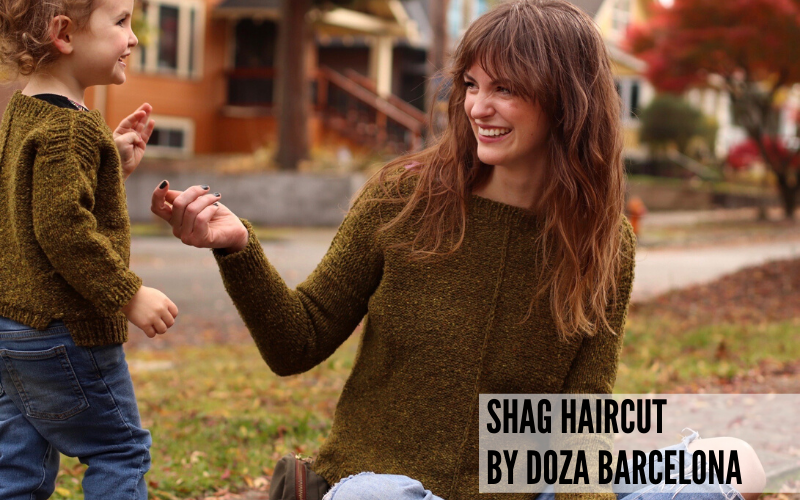 A stylish mom with a shag haircut playing with her son in matching sweaters. Haircut by Doza Barcelona.