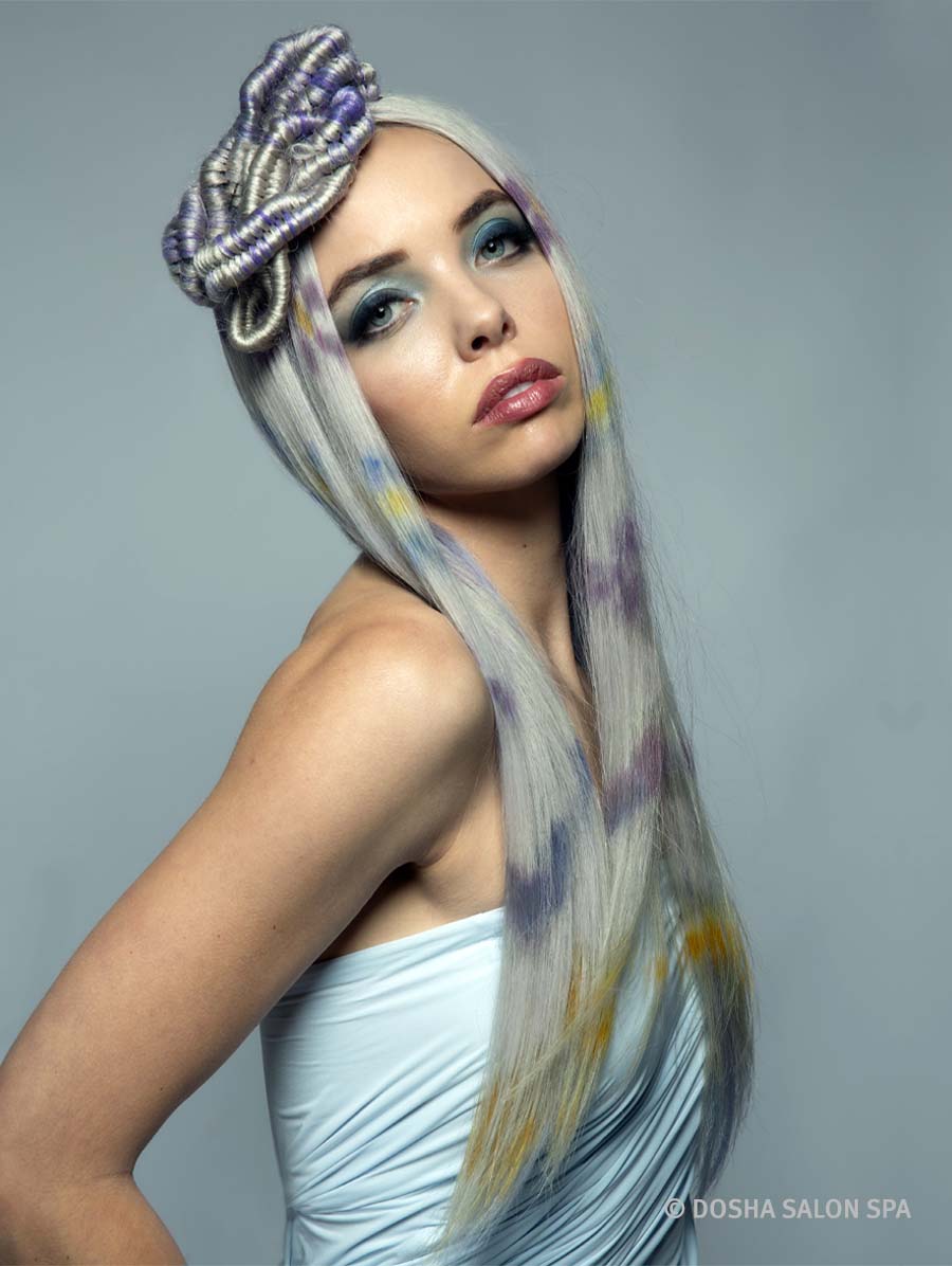 image of a dosha model with hair inspired by crater lake with flowers dyed into their hair and braids on top