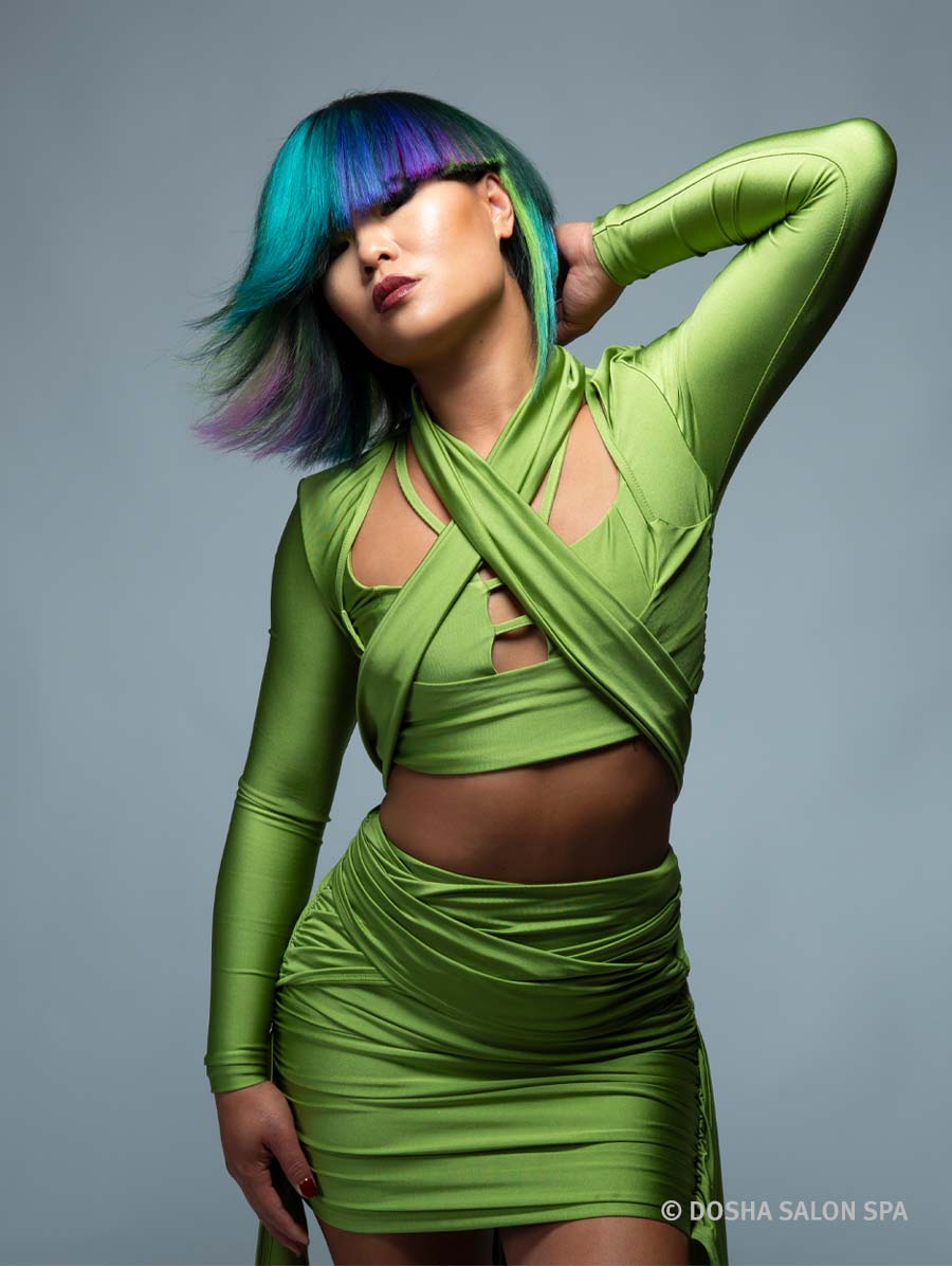 image of a dosha creative team model with hair in purple, green, blue and yellow that is inspired from mt wilderness