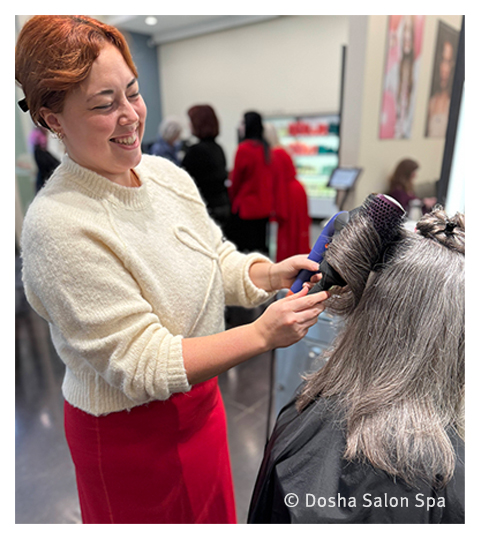 kayla working a client's hair with grey coloring